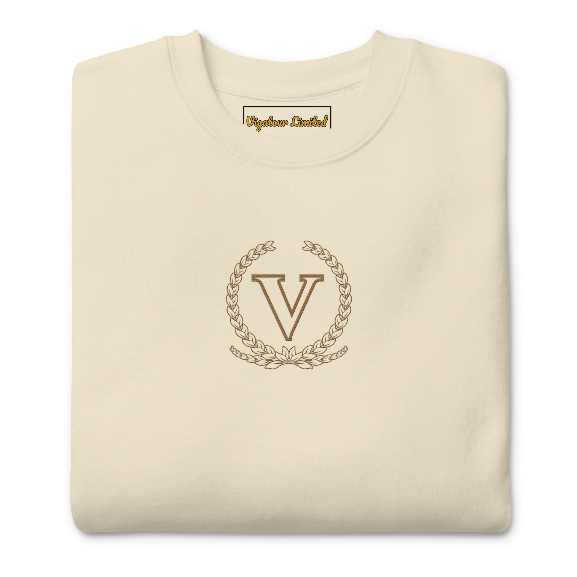 Folded beige sweatshirt with a gold emblem and 'V' letter on a white background